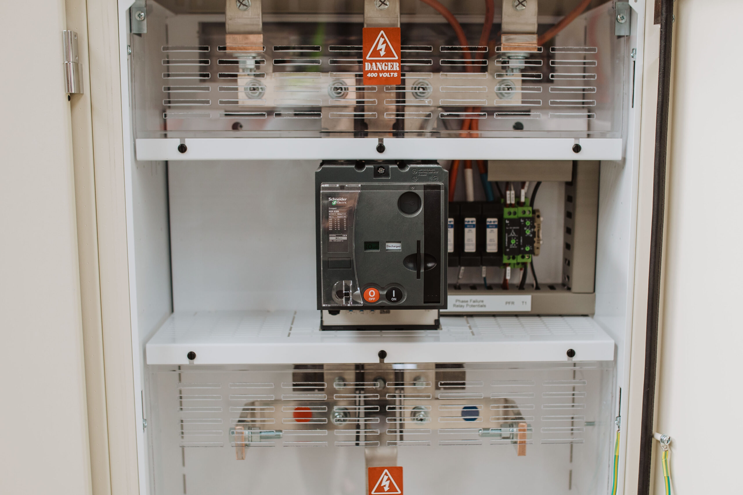 Interior of switchboard showing Schneider Electric main circuit breaker copper busbars and danger 400 volts sign by Clive Wilson Switchboards