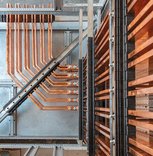 Detail shot of the Logstrup copper busbar system inside a switchboard, showing main busbar drops and droppers