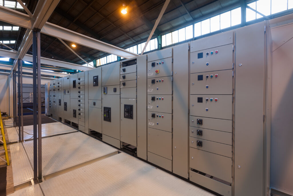 Switchboard lineup and checkerplate walkway inside a prefabricated switchroom at Clive Wilson Switchboards, Invercargill NZ